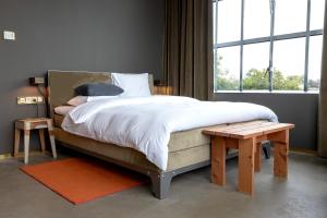 埃因霍温Hotel Piet Hein Eek的一间卧室设有一张大床和一个大窗户