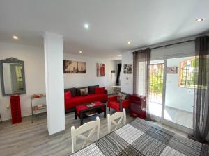 马萨龙港Blue Moon Apartment的客厅配有红色的沙发和桌子
