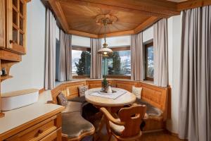 尼德恩西尔Alpine View Apartments的一间带桌子和一些窗户的用餐室