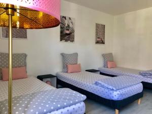 马尼库尔勒翁格尔House with garden Disneyland Paris的带三张床和粉红色灯的房间