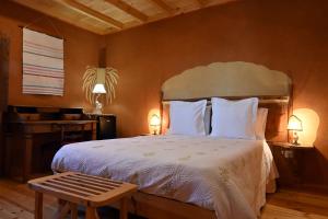 佩尼亚加西亚Casal da Serra的卧室配有一张带白色床单和长凳的大床