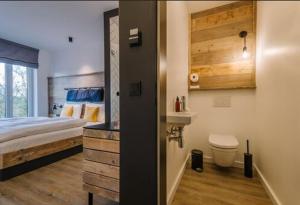 尼布尔Hotel Landhafen的一间卧室配有一张床,浴室设有水槽