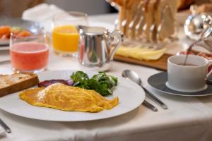 宏达瑞比亚Villa Magalean Hotel & Spa的包括一盘鸡蛋、果盘和烤面包的早餐桌
