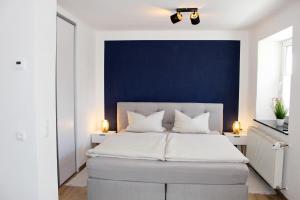 WeißenstadtFerienhaus Traumblick direkt am See的一间卧室设有一张蓝色墙壁的大床