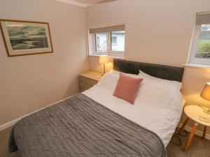 卡马森Dinefwr Cottage的一间卧室配有一张带白色床单和红色枕头的床