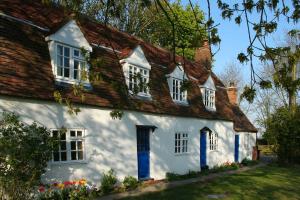 西默西The Wobbin, Remote, Comfort, Sea Views and the beautiful Essex Marshes的白色的房子,设有蓝色的门窗