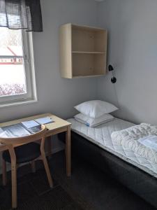 林雪平Valla Folkhögskola的小房间设有床、书桌和窗户