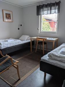 林雪平Valla Folkhögskola的客房设有两张床、一张桌子和一扇窗户。