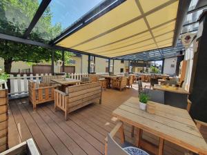 NeuhofLandhotel Imhof的餐厅设有木桌、长凳和大伞