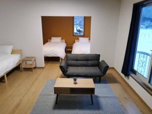 富良野All Seasons Furano Chalet的带沙发和2张床的客厅