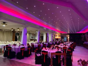 马特莱Hotel Spring View的宴会厅配有桌椅和紫色照明