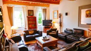 莱萨韦尼埃Domaine du Manoir的客厅配有皮革家具和电视