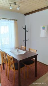 贝内茨科Apartmán Pod Žalým的餐桌、椅子和墙上的十字架