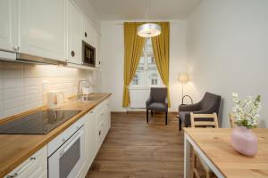 布拉格Unesco Prague Apartments的厨房配有白色橱柜和桌椅