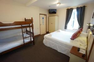 贝图瑟科伊德教堂山之家旅馆的一间卧室设有两张双层床和一扇窗户。