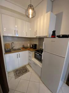 沃洛斯cozy apartment的厨房配有白色橱柜和白色冰箱。