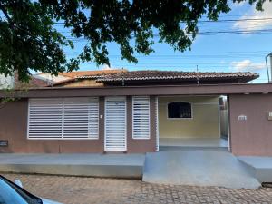 巴拉多库努casa em Barra de Cunhaú-RN的上面有白色百叶窗的房子