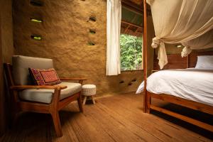 LamasChirapa Manta Amazon Lodge的卧室配有床、椅子和窗户。