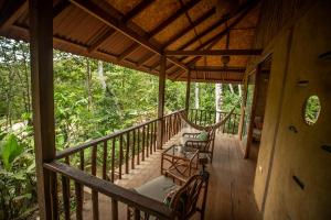 LamasChirapa Manta Amazon Lodge的一个带两把椅子和吊床的房屋门廊