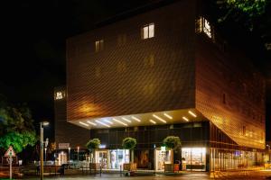 阿拉斯ibis Styles Arras Centre的一座砖砌的建筑,晚上有灯