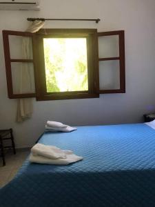 StavrokhórionPericles Traditional Cretan Home的卧室配有带2条毛巾的窗户,位于床上