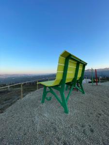 郎世宁蒂内拉Albergo Castiglione Langhe的坐在山顶上的绿色和黄色椅子