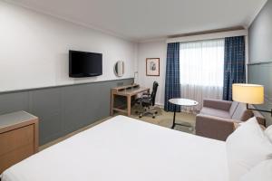 赫尔假日赫尔海滨酒店的配有一张床和一张书桌的酒店客房