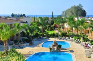Paphos2 Bedroom Maisonette Mandria Paphos Cyprus的度假村设有两个游泳池和棕榈树