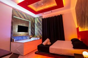 庞贝Pompei Luxury Rooms的一间卧室配有一张床、一个浴缸和一台电视。