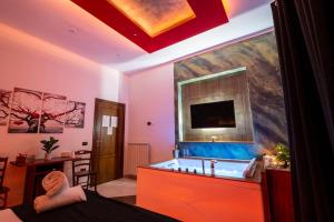 庞贝Pompei Luxury Rooms的带浴缸的浴室和墙上的电视