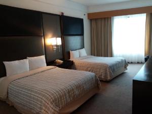 巴拿马城Hospedium Princess Hotel Panamá的酒店客房设有两张床和窗户。