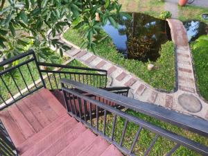 蒂瑟默哈拉默Village Mango Resort Yala的池塘旁的楼梯上的木凳