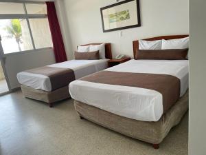 韦拉克鲁斯皇家酒店的酒店客房设有两张床和窗户。