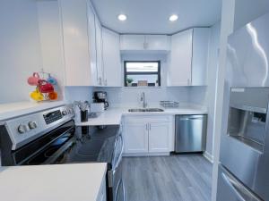 迈阿密Great Stay in South Florida! -D-Centrally located的白色的厨房,配有白色橱柜和不锈钢用具