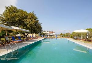沃尔沃罗Villa Vasiliadi的一个带椅子和遮阳伞的大型游泳池