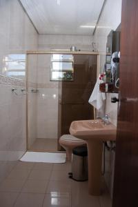 普拉杜斯Apart Hotel Água Limpa的带淋浴、卫生间和盥洗盆的浴室