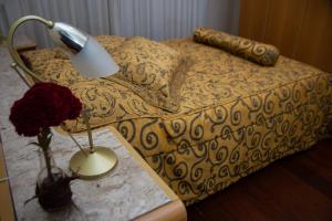 普拉杜斯Apart Hotel Água Limpa的一间卧室配有一张带台灯和桌子的床