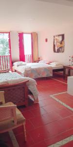 萨兰托Hotel Natura Cocora的客房设有两张床,铺有红色瓷砖地板。