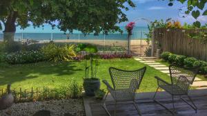 峇都丁宜Smell rose beach garden的一个带两把椅子和一张桌子的庭院和海滩