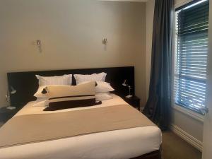 卡德罗纳Cardrona Mountain Villa的卧室配有一张带白色床单和枕头的大床。