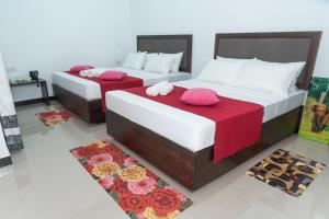 丹不拉Sadee's Place的红色床单的客房内的两张床