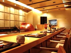 宇都宫宇都宫中心酒店的一个带长长台面和椅子的大厨房