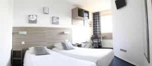塞特港B&B HOTEL Sète Centre Gare的配有白色床单的酒店客房内的两张床