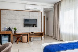 瓦亚纳德Oshin Hotel的酒店的客房,配有书桌和墙上的电视