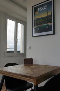 波城Ultra centre - Certainement la plus belle vue de Pau的带2扇窗户的客房内的木桌