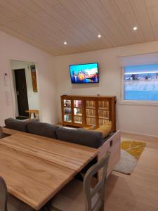 罗瓦涅米Arctic River Chalet的客厅配有沙发和墙上的电视