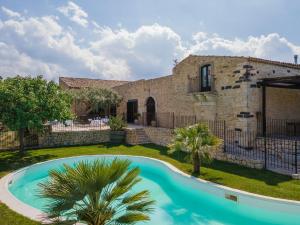 BuccheriMasseria Fortificata Lo Zafferaneto的一座别墅,在一座建筑前设有一个游泳池