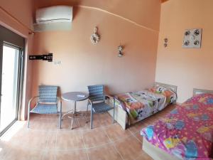 AlikíStone Villa at Alyki Beach的卧室配有一张床和一张桌子及椅子
