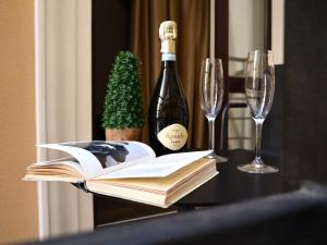 敖德萨Kuprin Hotel的一张桌子,上面放着书籍和一瓶葡萄酒及眼镜