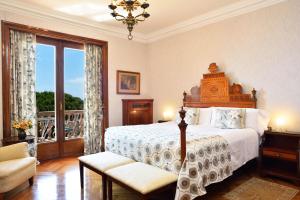萨卡罗Hostal de la Gavina GL - The Leading Hotels of the World的一间带大床的卧室和一个阳台